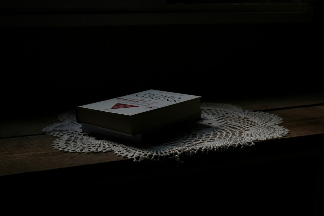 Dark mystery novel book cover on a wooden table